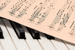 Imagen de inicio de la página web, aparecen las teclas de un piano y una partitura encima del piano.